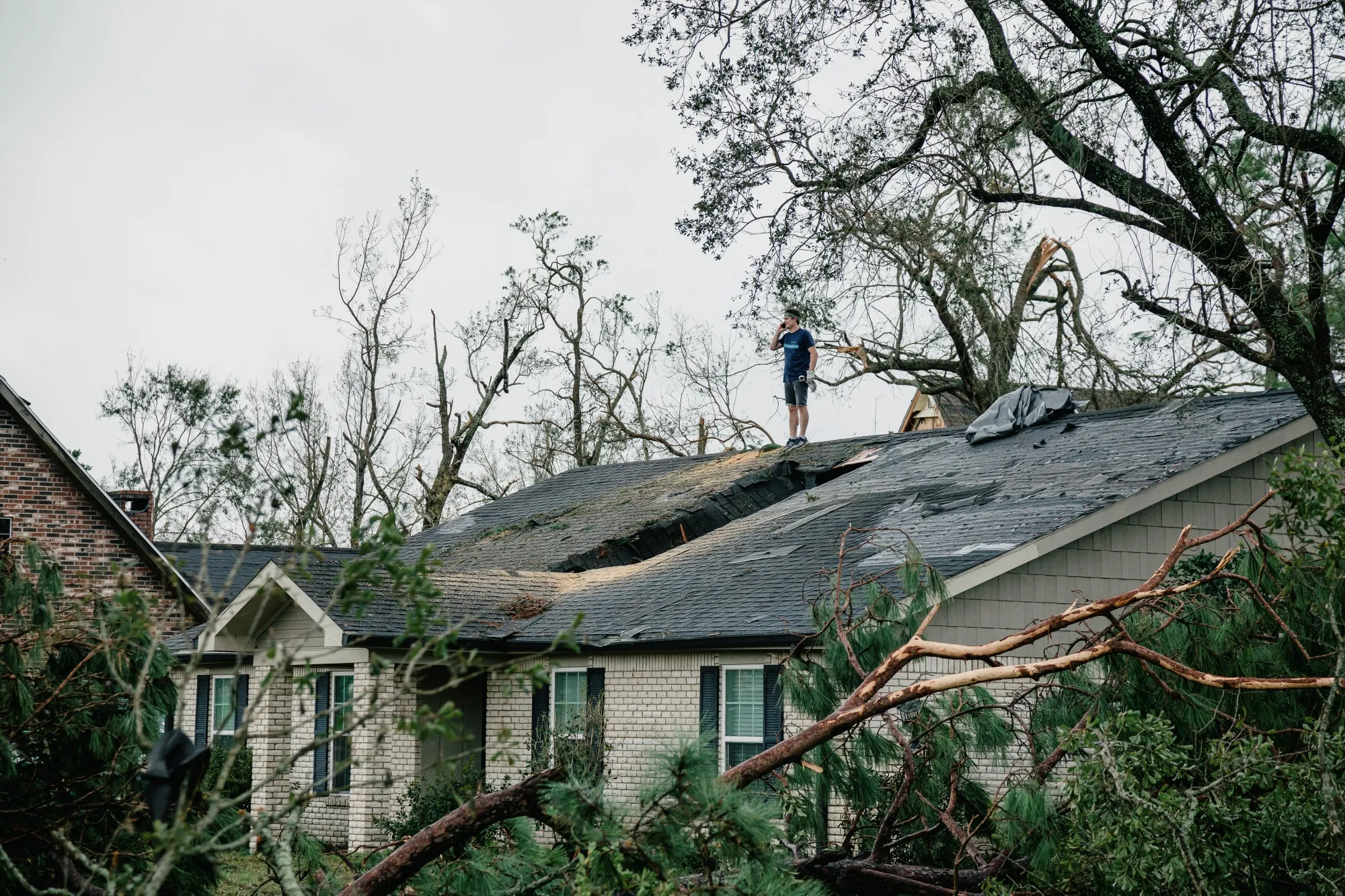 A resident stands next to a hole in the roof of a damaged home in Lake Charles, Louisiana on Aug. 28.