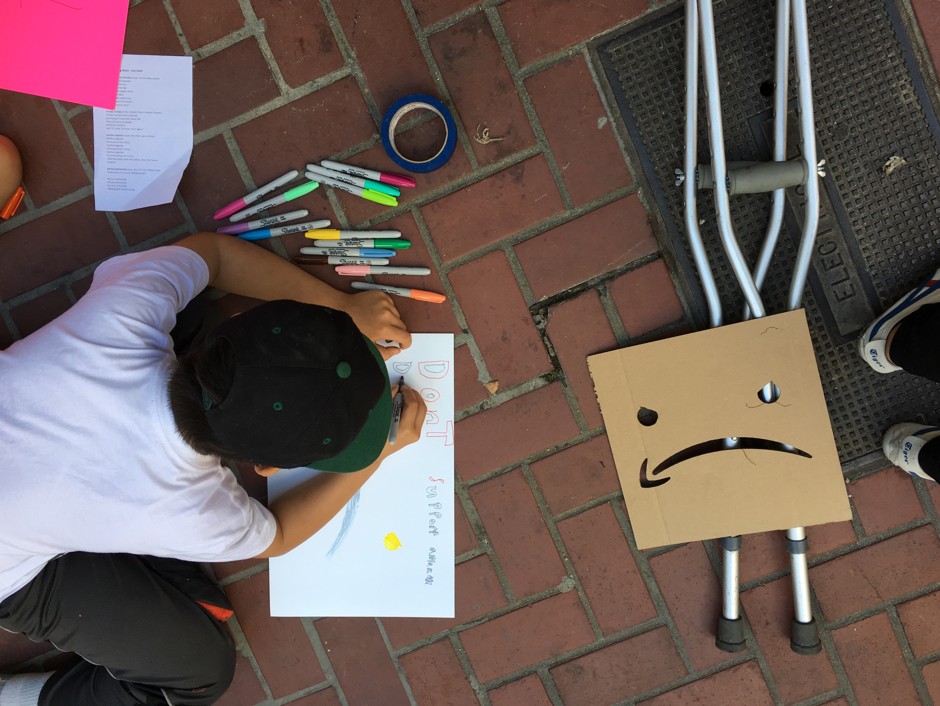A child draws an anti-Amazon protest sign at the Climate Strike march in San Francisco.