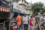 Customers wearing protective masks wait in line at a dairy store during a lockdown imposed due to the coronavirus in Mumbai, India.