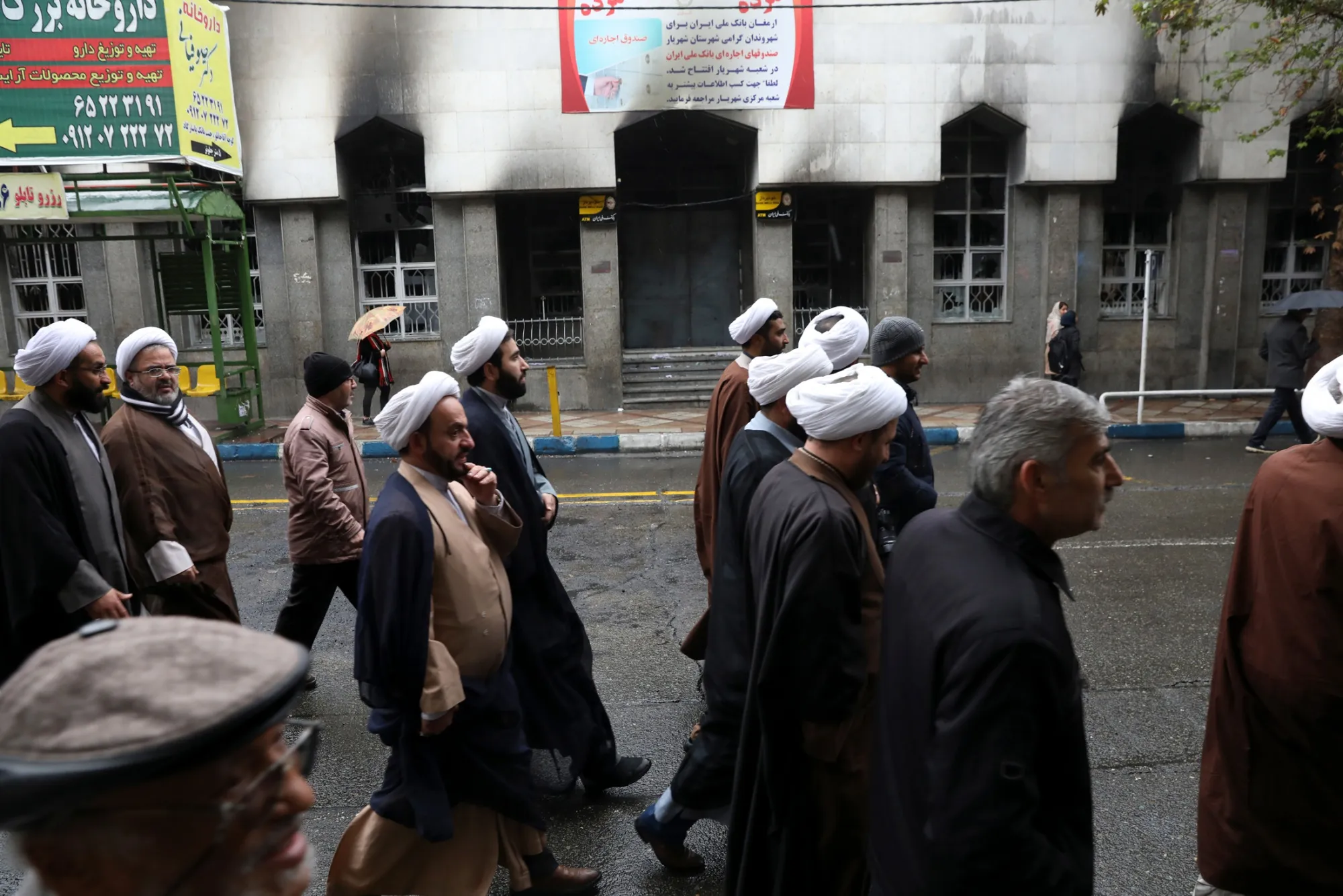 Clerics attend a funeral procession near a bank building damaged during recent protests, in Shahriar, Iran, on Nov. 20.