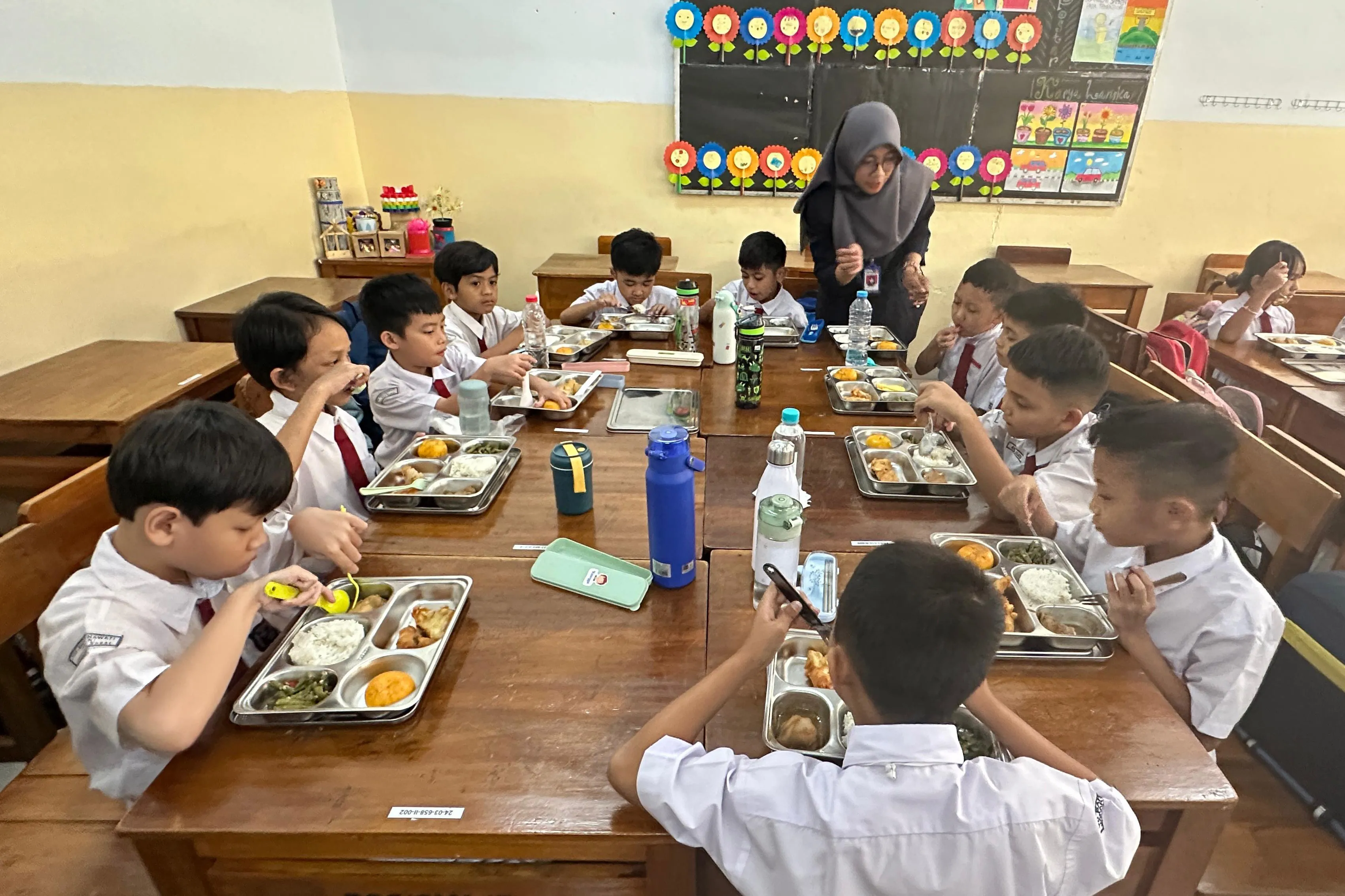 Children receive free meals at a school in Jakarta on Jan. 6.