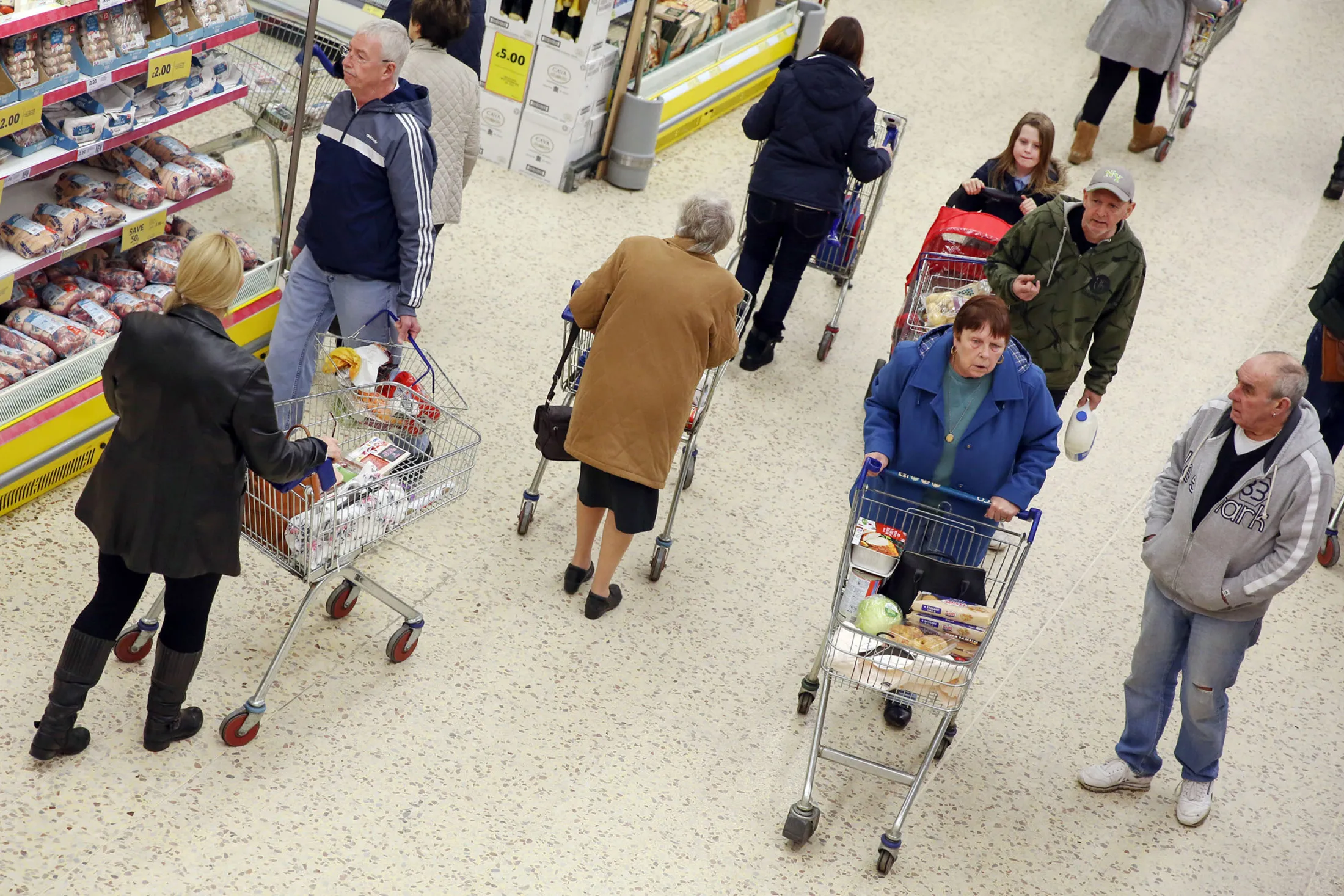 Shoppers make their way along the central aisle at a Tesco Plc supermarket in Basildon, U.K., on Friday Dec. 1, 2015. .
