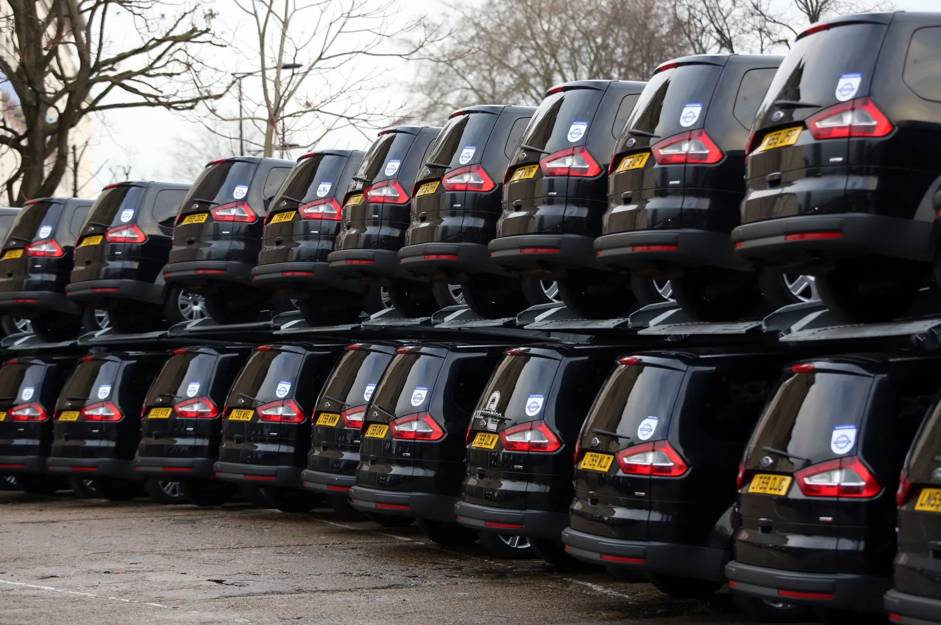 Minicabs operated by Addison Lee on a lot in London.