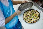 A chef prepares a pizza for a takeaway order in Riyadh, Saudi Arabia.