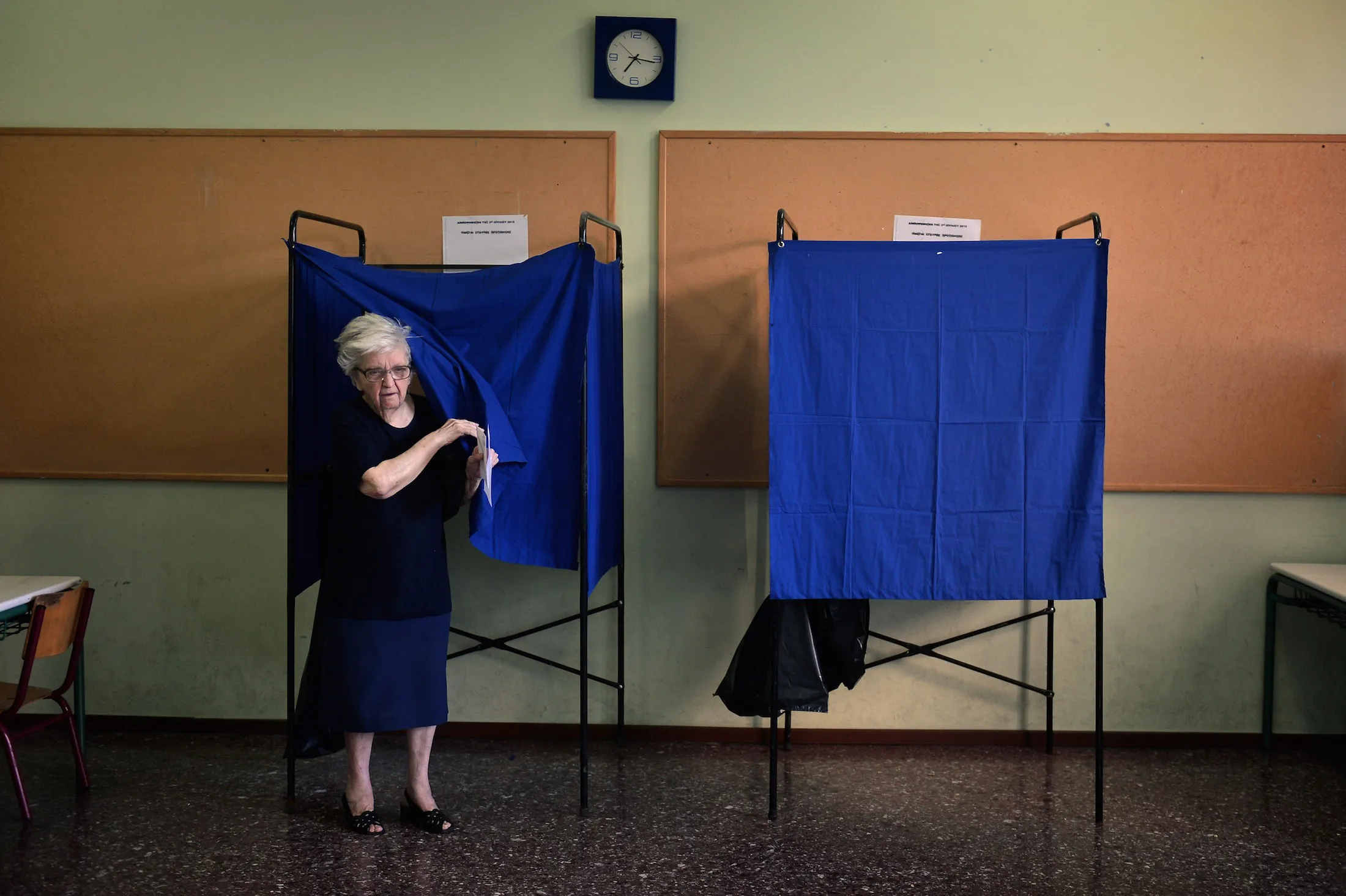 A woman comes out of a polling booth during the Greek referendum in Athens on July 5, 2015. Nearly 10 million Greek voters headed to the polls today to vote in a historic, tightly fought referendum on whether to accept worsening austerity in exchange for more bailout funds, in a gamble that could see it crash out of the euro. AFP PHOTO / LOUISA GOULIAMAKI (Photo credit should read LOUISA GOULIAMAKI/AFP/Getty Images)
