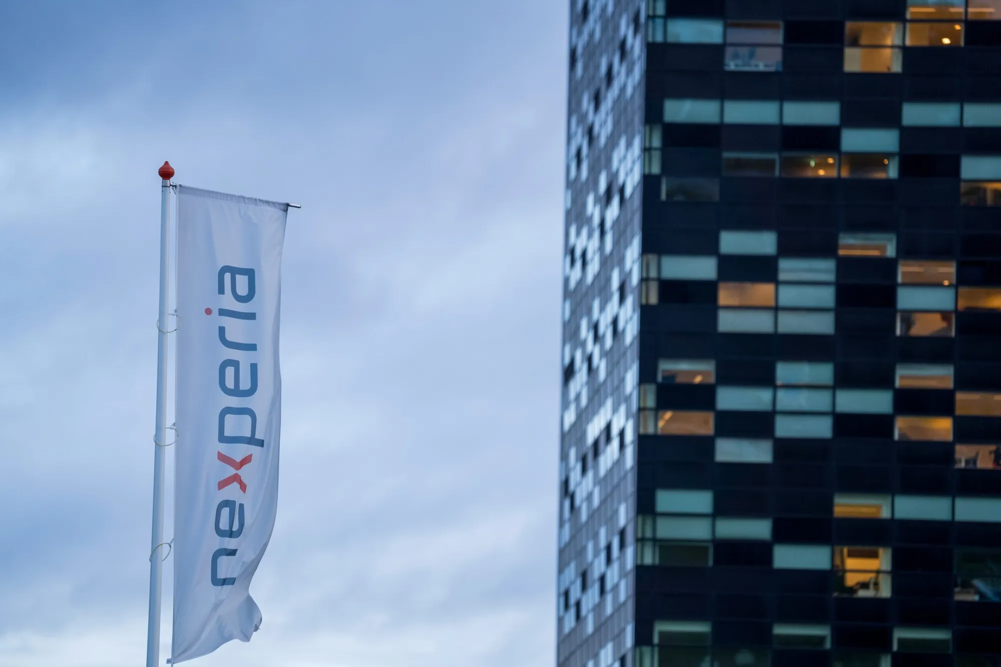 A banner flag with the Nexperia Holding BV logo outside their headquarters on the Noviotech Campus in Nijmegen, Netherlands, on Oct. 24, 2025.