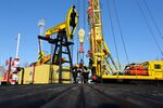 Workers perform a well-workover operation at a multiple well platform, operated by Rosneft PJSC, in the Samotlor oilfield near Nizhnevartovsk, Russia.