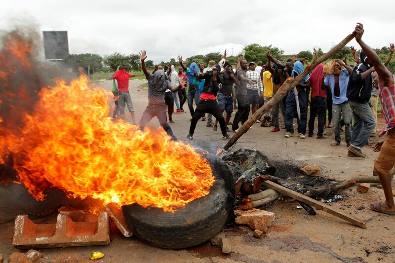 Protestors gather near a burning tire in Harare, on Jan. 15.