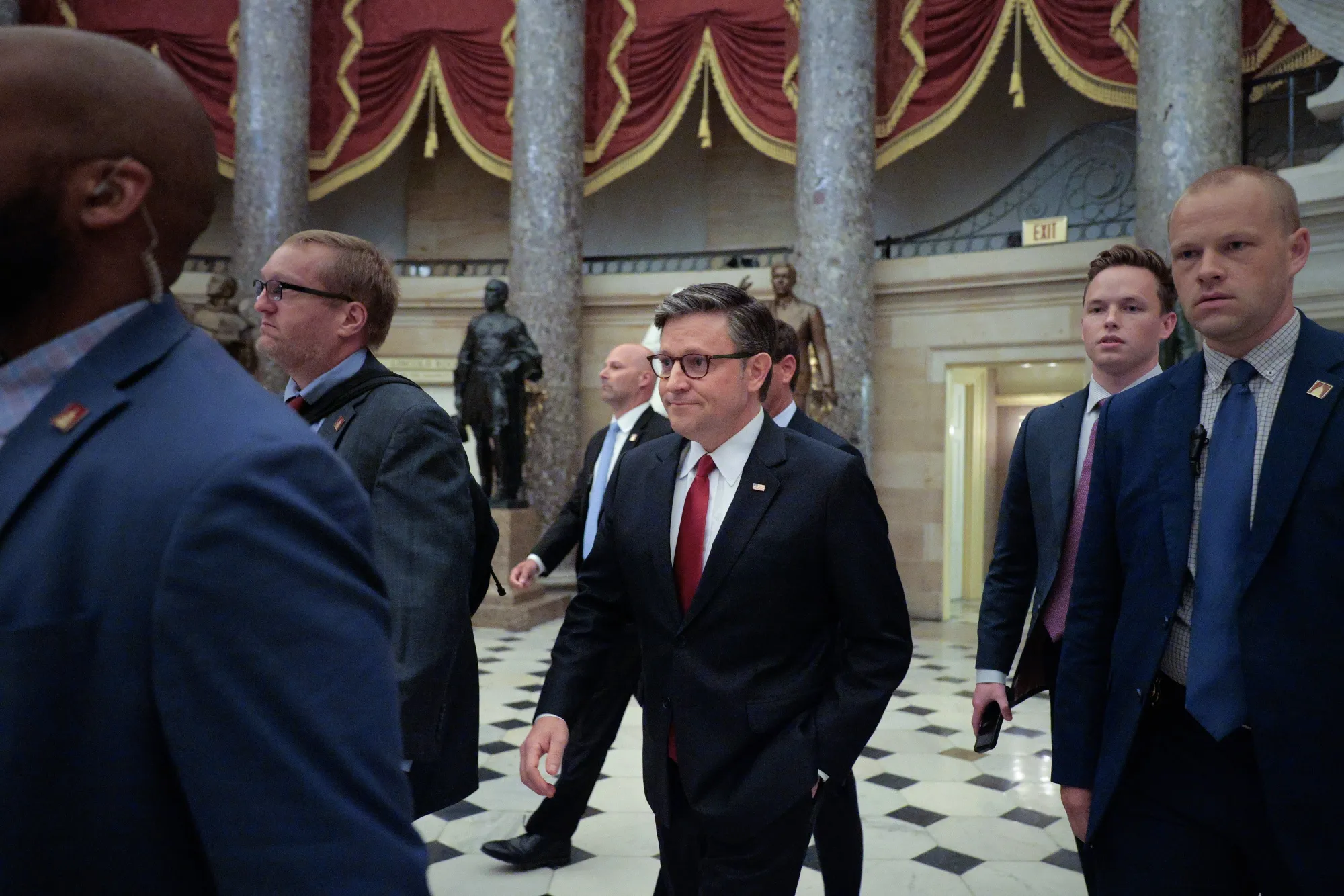 US House Speaker Mike Johnson is surrounded by security and staff at the US Capitol in July.