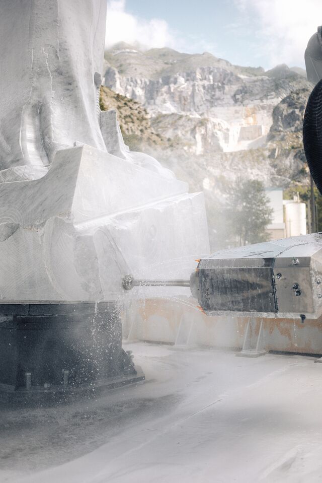 A robot carving a statue depicting Sai Baba.