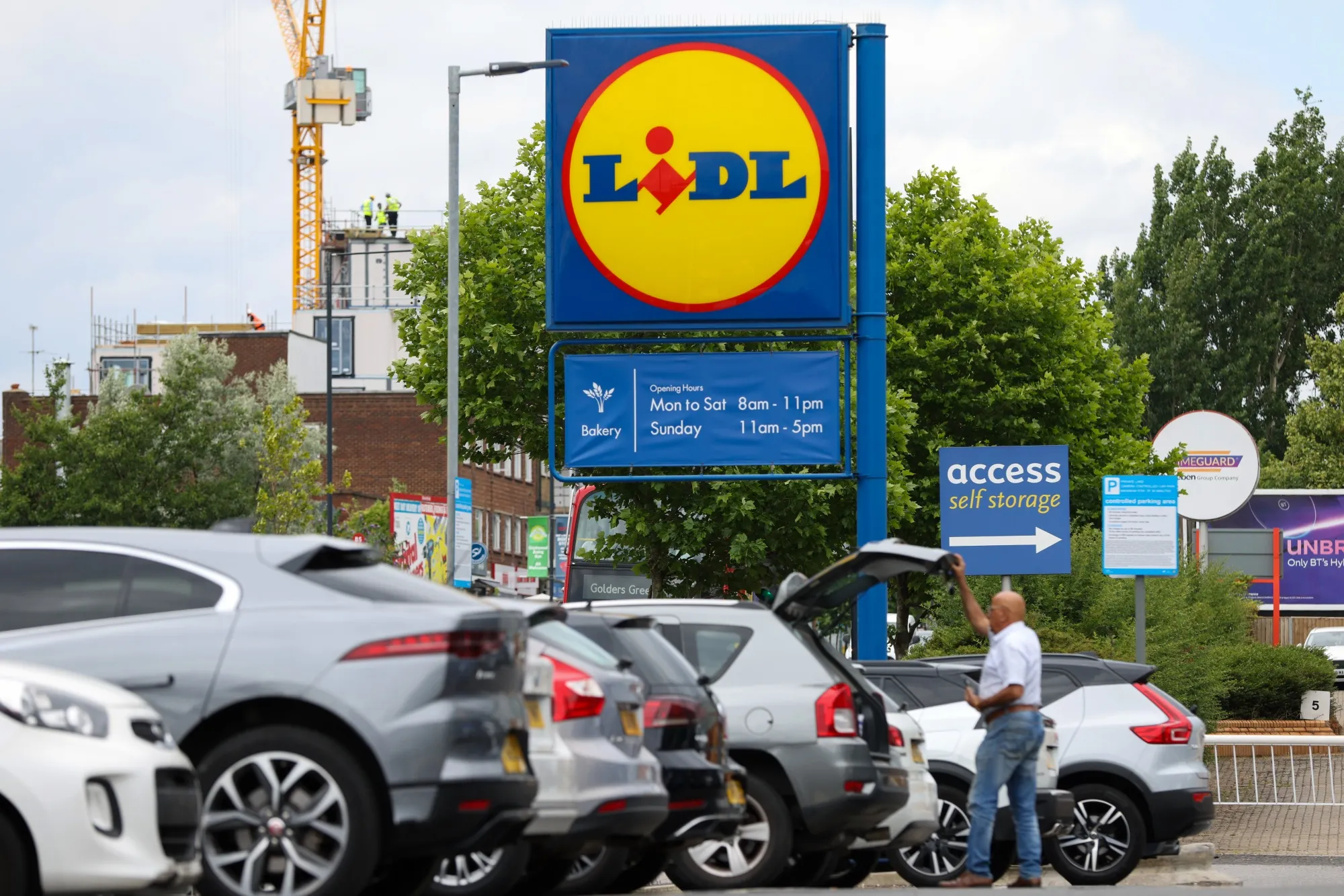 A customer loads a car boot with groceries from a Lidl Ltd. supermarket in London, UK.