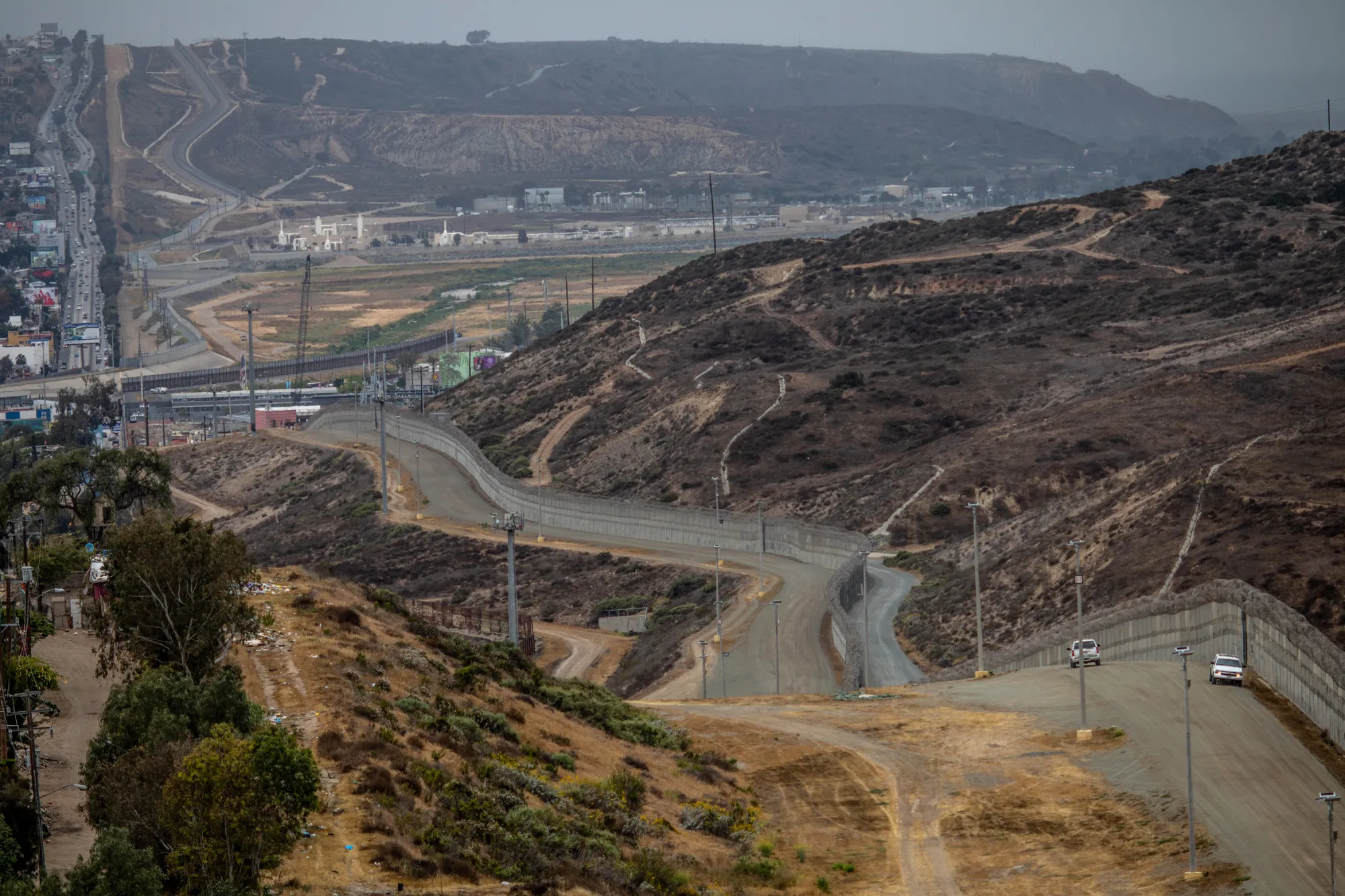 Border Patrol vehicles sit near a section of the U.S.-Mexico border wall in Tijuana, Mexico, on Monday, May 21, 2018.