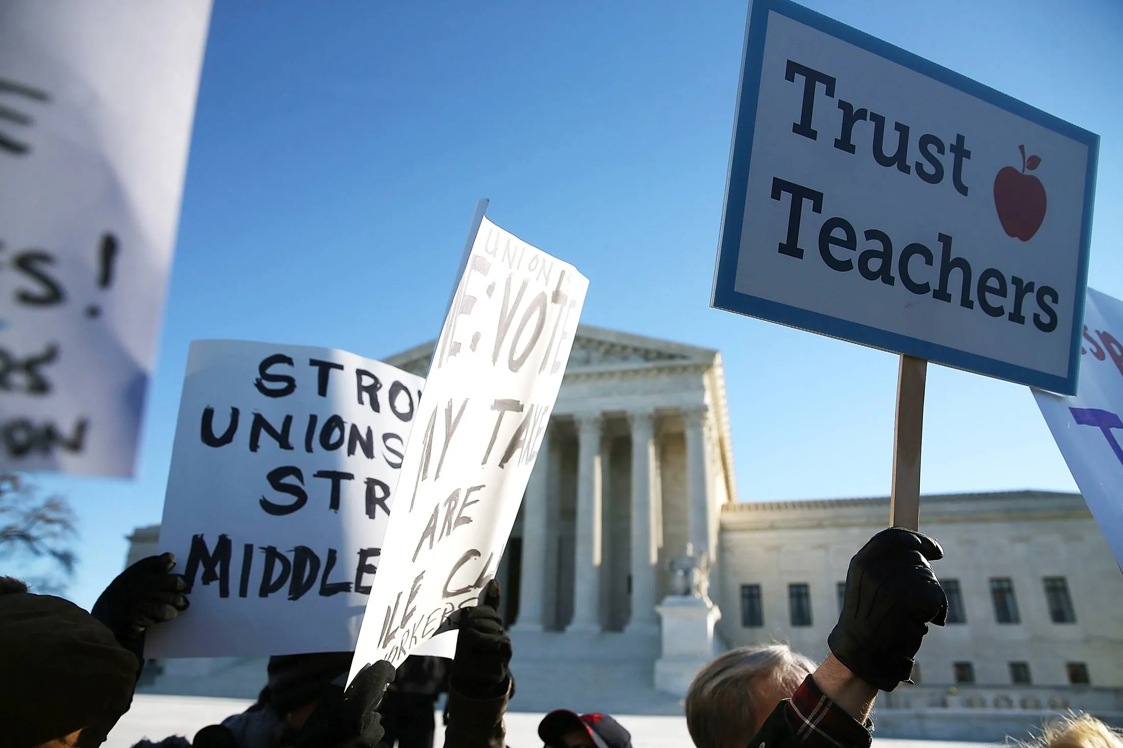 People for and against unions hold up signs in front of the Supreme Court building Jan. 11, in Washington, DC.

