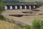 Traffic crosses a bridge on the A628 trunk road over the dry bed of Woodhead Reservoir in Longdendale, UK.