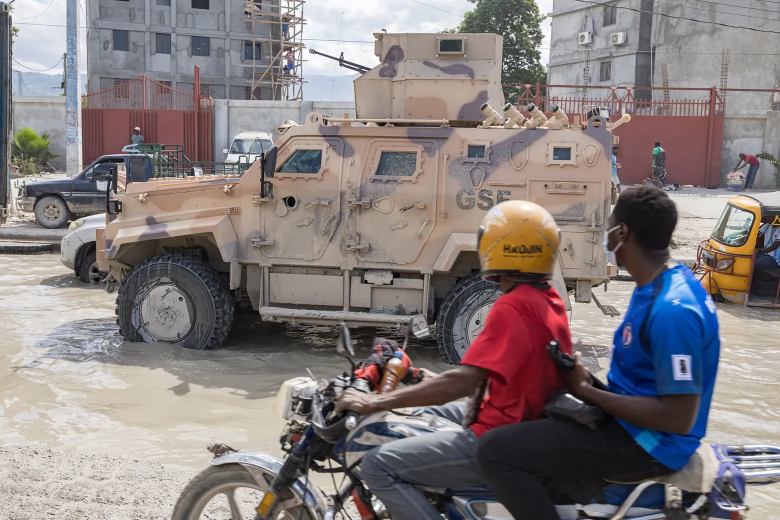 A motorcyclist rides along a street amid a traffic jam as several military vehicles pass by in Port-au-Prince, Haiti, on Oct. 24.