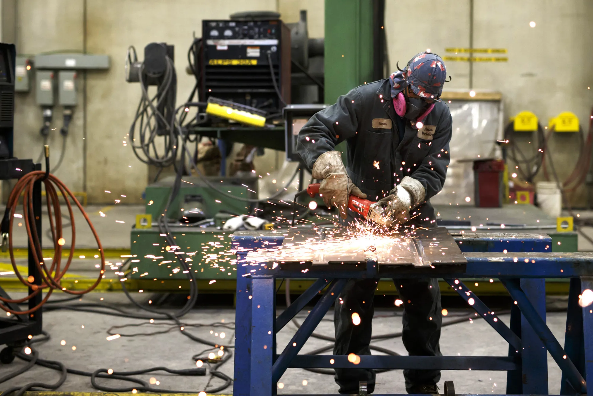 Sparks fly as a worker operates a grinder tool at the Alps Welding Ltd. facility in Toronto, Ontario, Canada.
