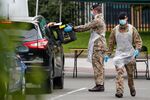 A member of the U.K. armed forces takes a completed Covid-19 test from a driver at a mobile testing centre in Leicester, U.K., on June 29.