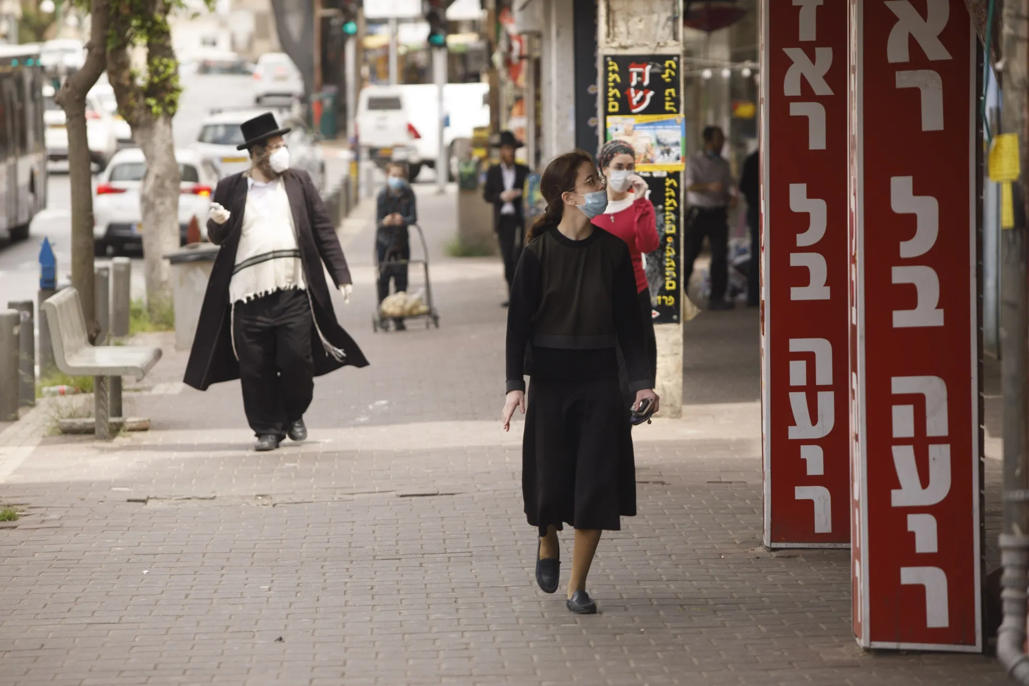 Residents wearing protective face masks walk along a street in Bnei Brak, Israel, on April 6.