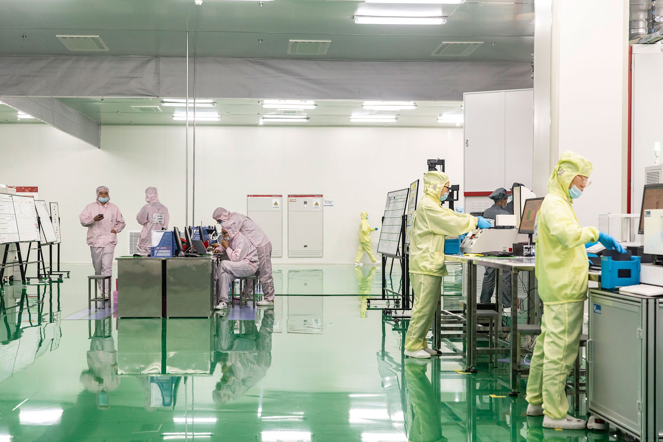 Employees operate on the newly opened photovoltaic cell production line of Longji Solar in Xi'an China, on Tuesday, 21 July 2020.