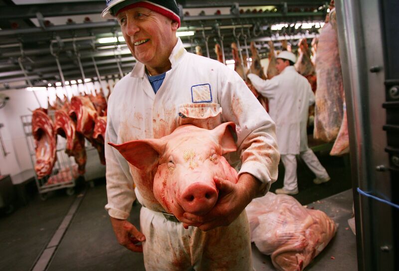 A butcher holds a pig's head at the Smit