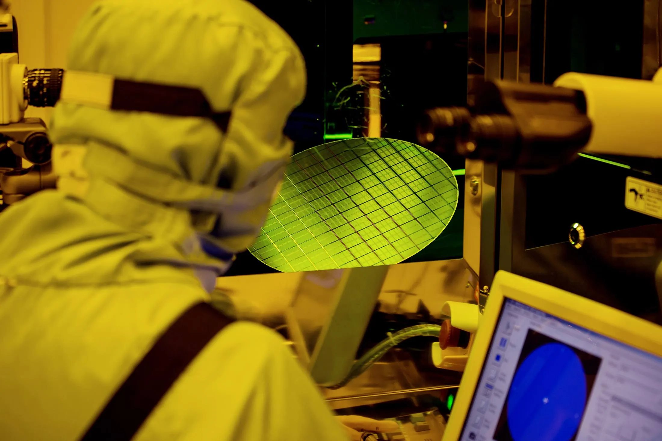 An employee inspect wafers using an optical microscope at a facility in Taichung, Taiwan, in 2016.&nbsp;