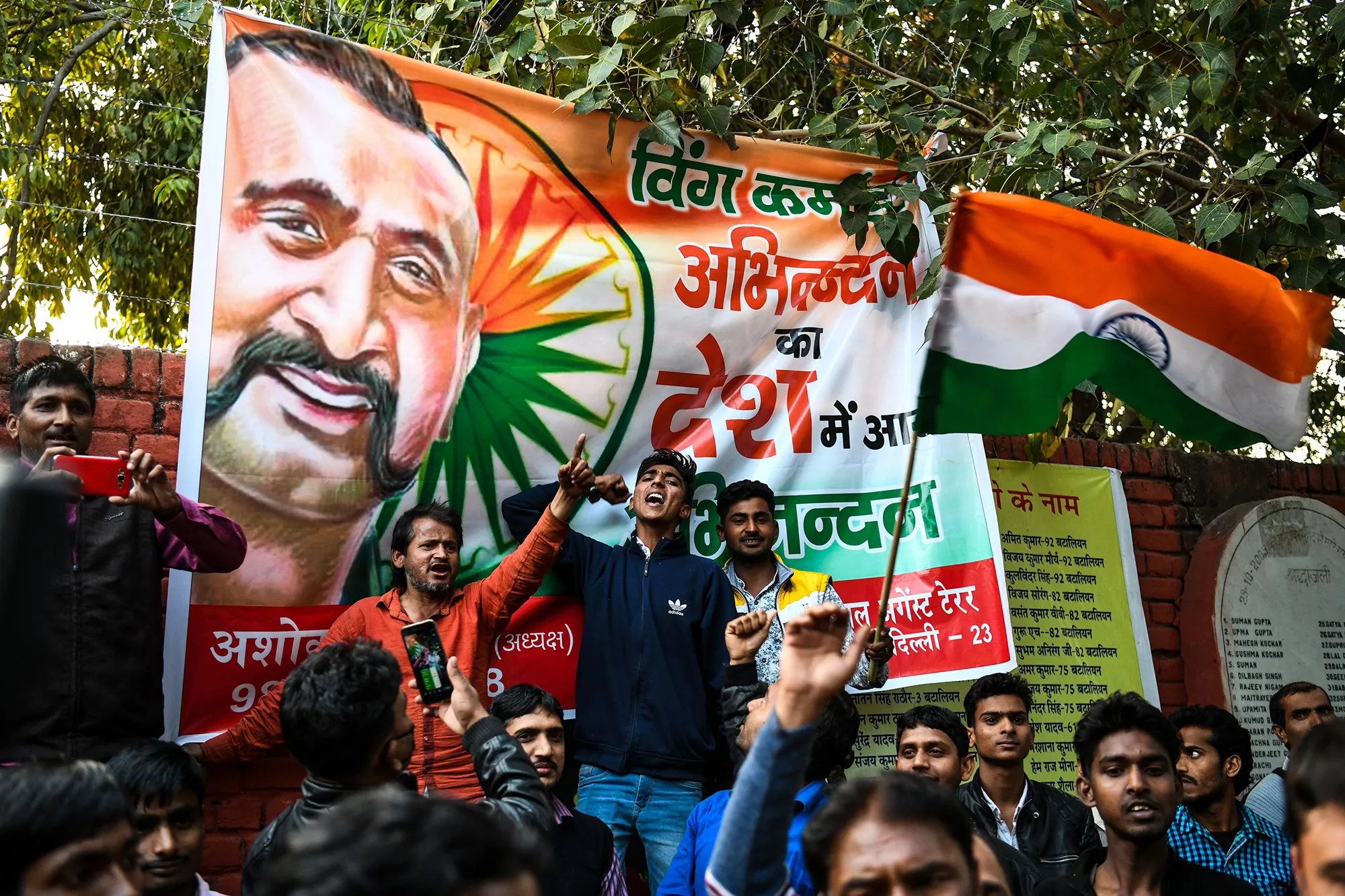 People celebrate with a banner of Commander Abhinandan Varthaman&nbsp;in New Delhi on March 1, 2019.