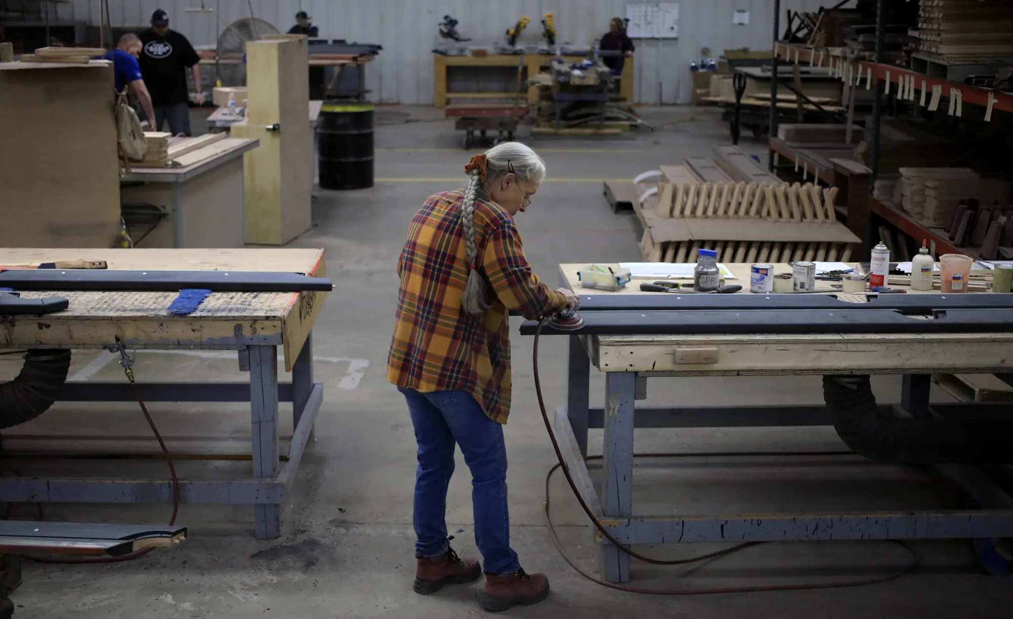 A worker sands wood components for a pool table in Jeffersonville, Indiana.