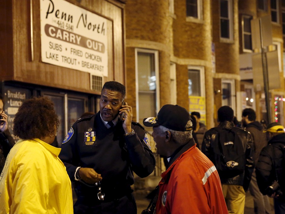Baltimore Police Lt. Colonel Melvin Russell (center) talks to citizens on the streets of the Penn North section of Baltimore December 16, 2015. 