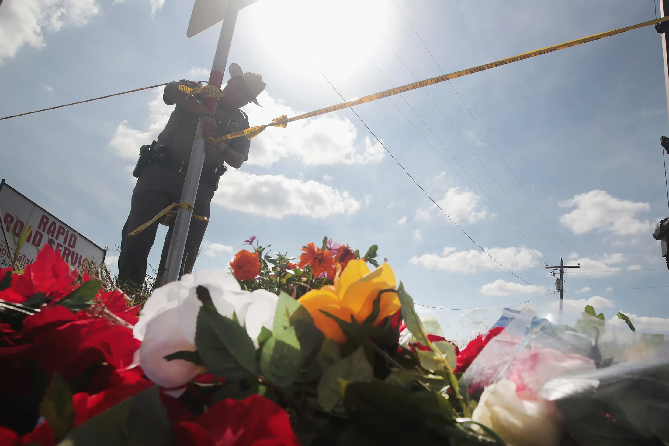 A police officer ties off crime scene tape near a small memorial close to the First Baptist Church of Sutherland Springs on Nov. 7.