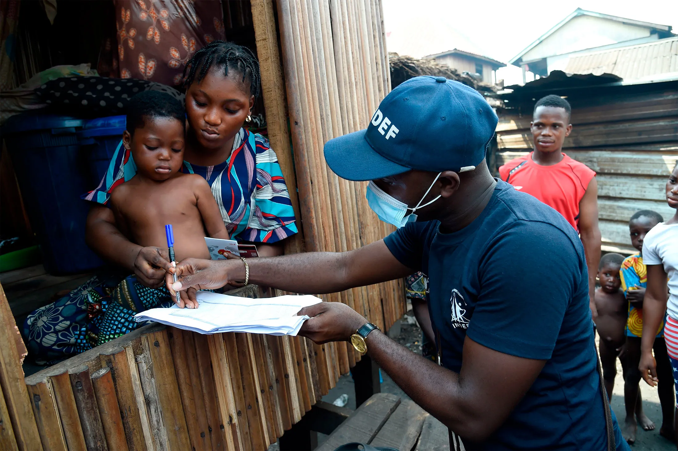 A resident receives a pre-paid debt card for cash and food provided by World Food Programme in a makeshift home in the Makoko riverine slum settlement in Lagos, Nigeria in 2020.