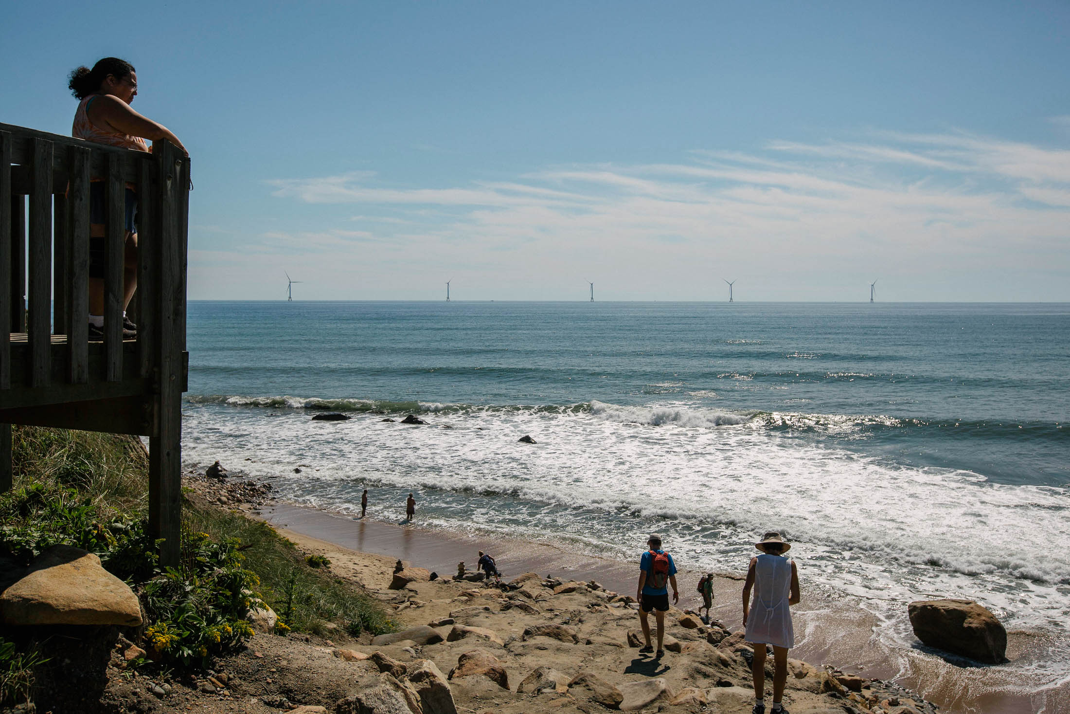 Tourists look out from a beach at the GE-Alstom Block Island Wind Farm, three&nbsp;miles off the coast of&nbsp;Block Island in&nbsp;Rhode Island.