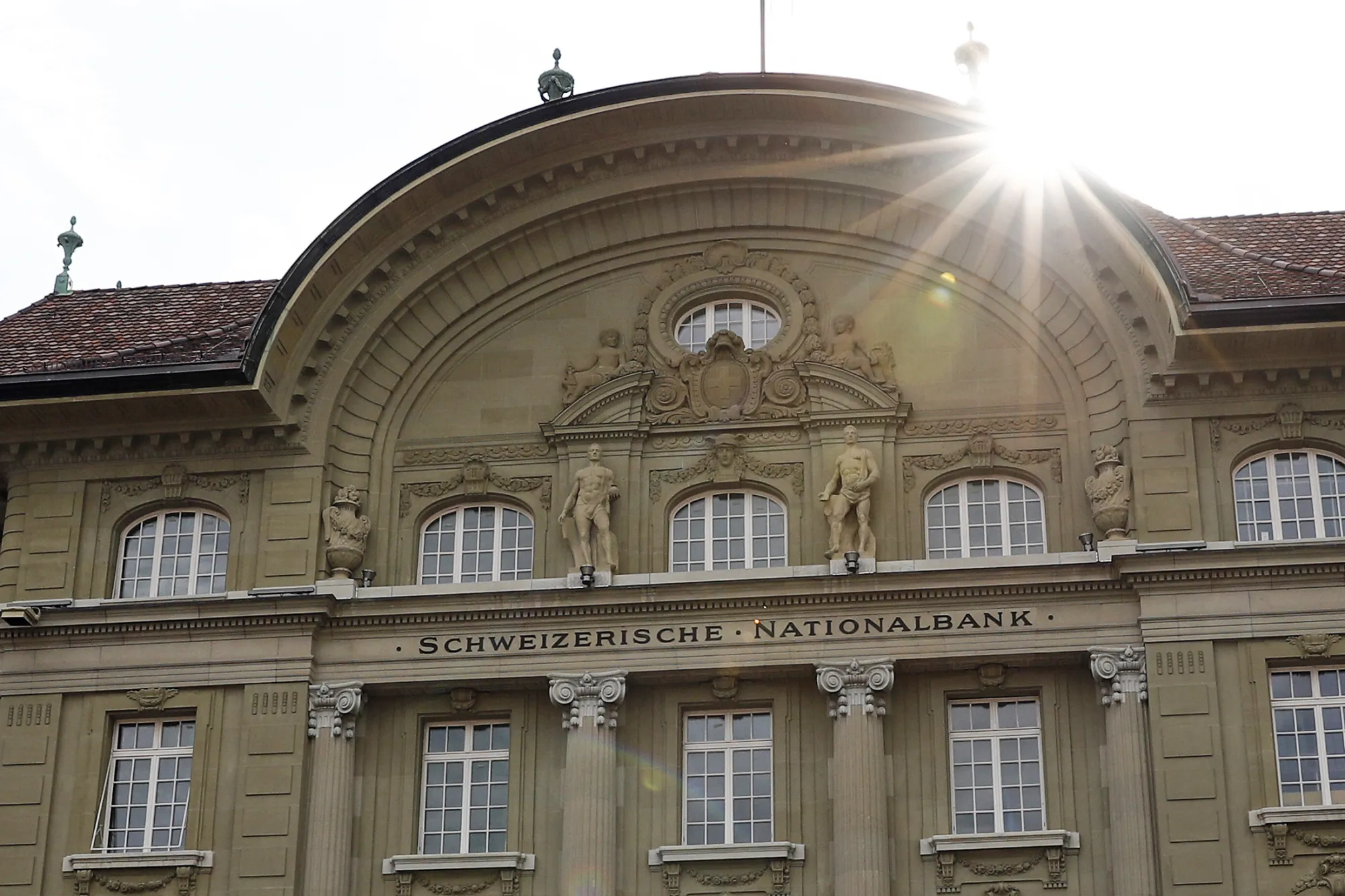 The sun rises behind the Swiss National Bank (SNB) building in Bern, Switzerland.