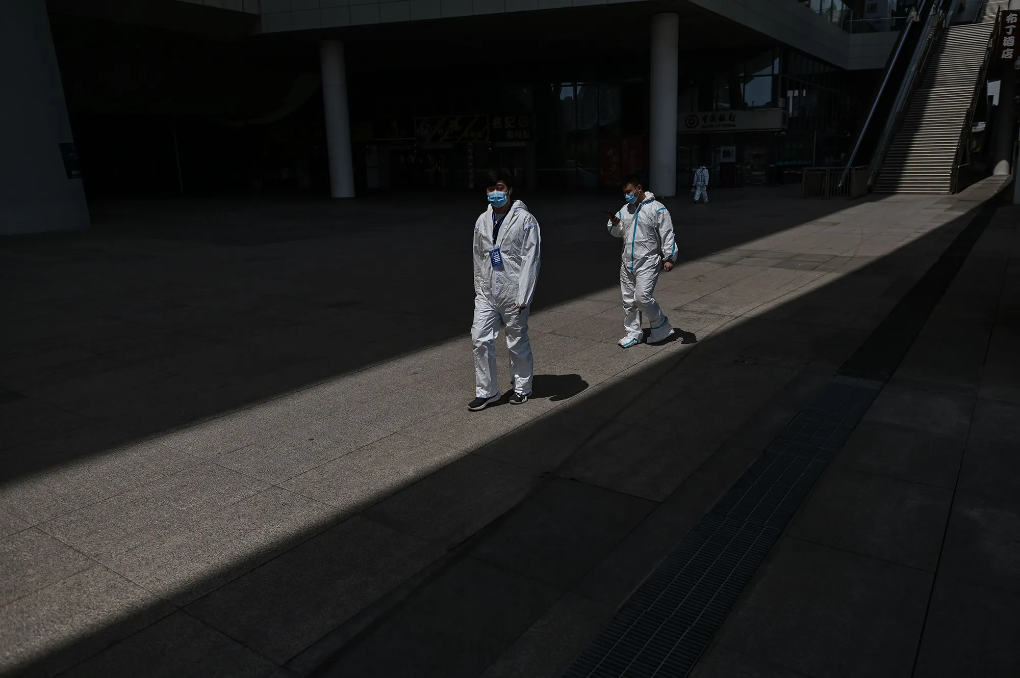 Workers wearing protective suits walk at the station in Wuhan, China,&nbsp;on April 6.
