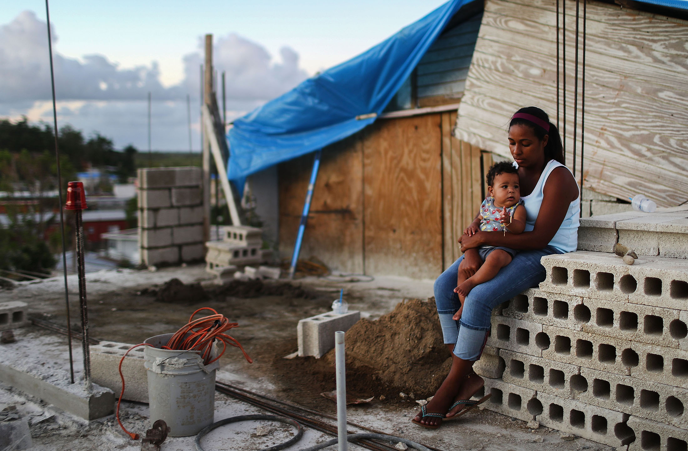 A mother&nbsp;holds her baby&nbsp;at their makeshift home, under reconstruction, after being mostly destroyed by Hurricane Maria,&nbsp;in San Isidro, on Dec. 23, 2017.&nbsp;