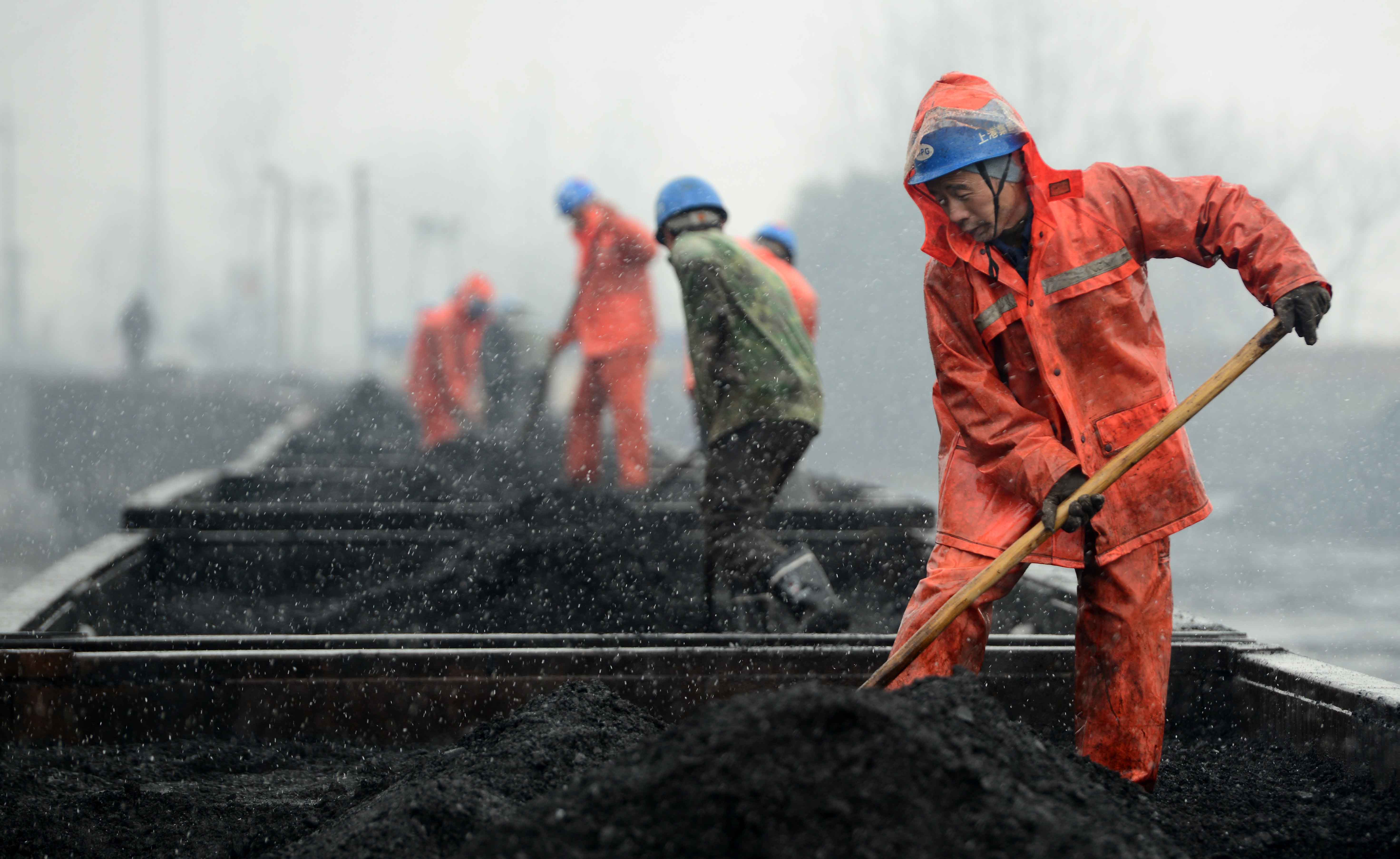 Workers work on the coal carriages at a railway station in China's Jiangxi province.