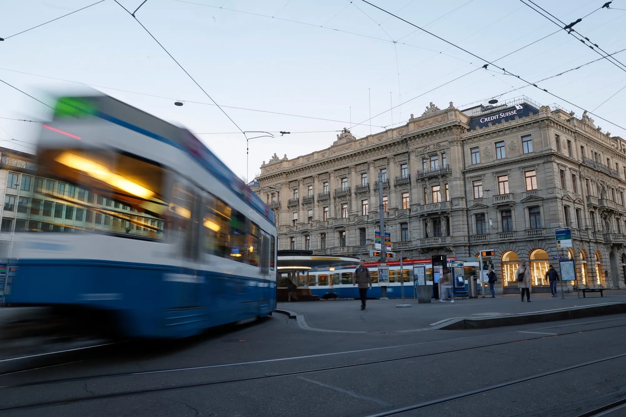 Trams travel past the Credit Suisse Group AG headquarters in Zurich, Switzerland.