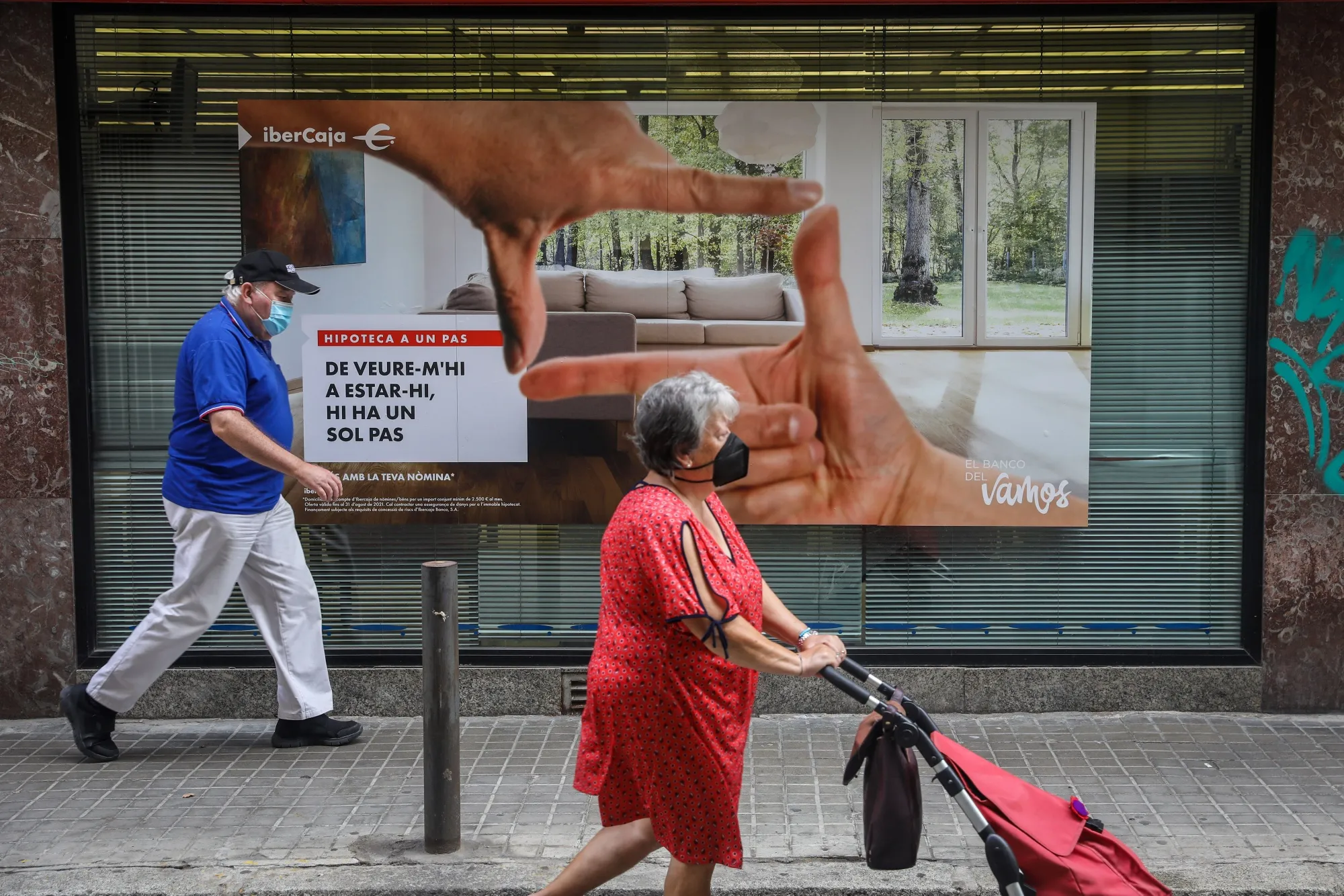Elderly pedestrians pass an Ibercaja Banco SA bank branch in Barcelona, Spain, on Friday, Sept. 3, 2021.&nbsp;