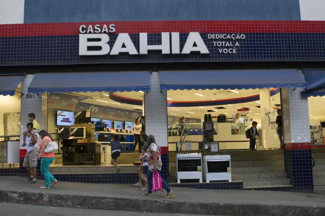 People walk past a Casas Bahia appliance store in the Rocinha favela in Rio de Janeiro, Brazil, on Thursday, Aug. 20, 2015.&nbsp;