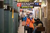 A commuter wearing a protective mask and face shield walks through a subway station platform during morning rush hour in New York on Monday, June 22, 2020.