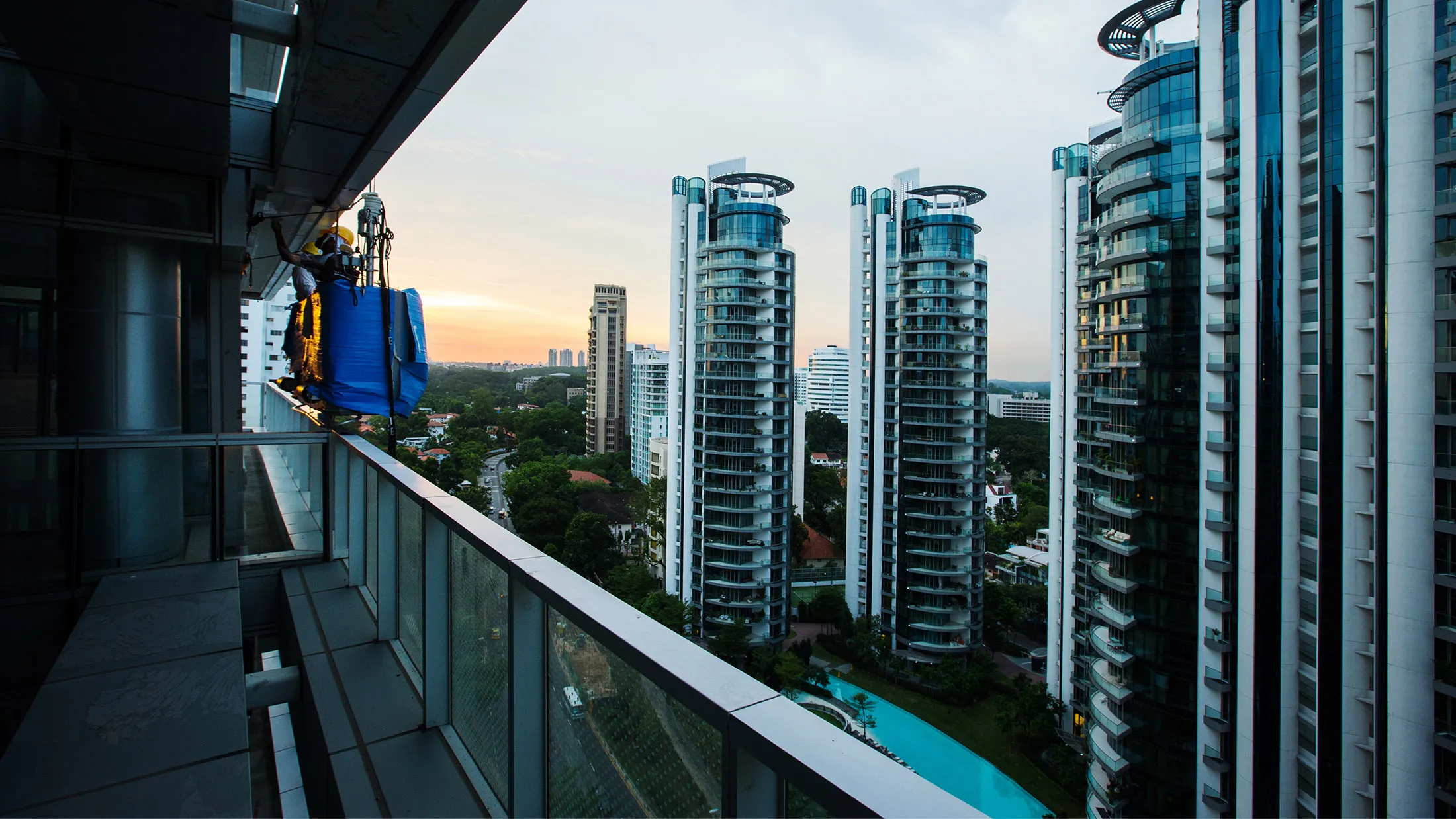 A worker rides a suspended platform as he performs construction work at a residential building at Gramercy Park, a freehold residential project developed by City Developments Ltd., in Singapore, on Thursday, May 19, 2016. City Developments, Singapore's second-largest developer, may seek to buy offices this year as rising interest rates makes such assets cheaper worldwide.
