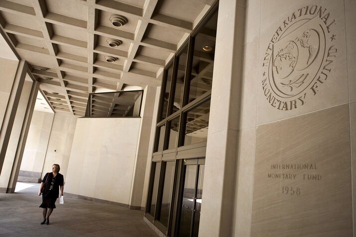 A woman walks in front of the International Monetary Fund bu