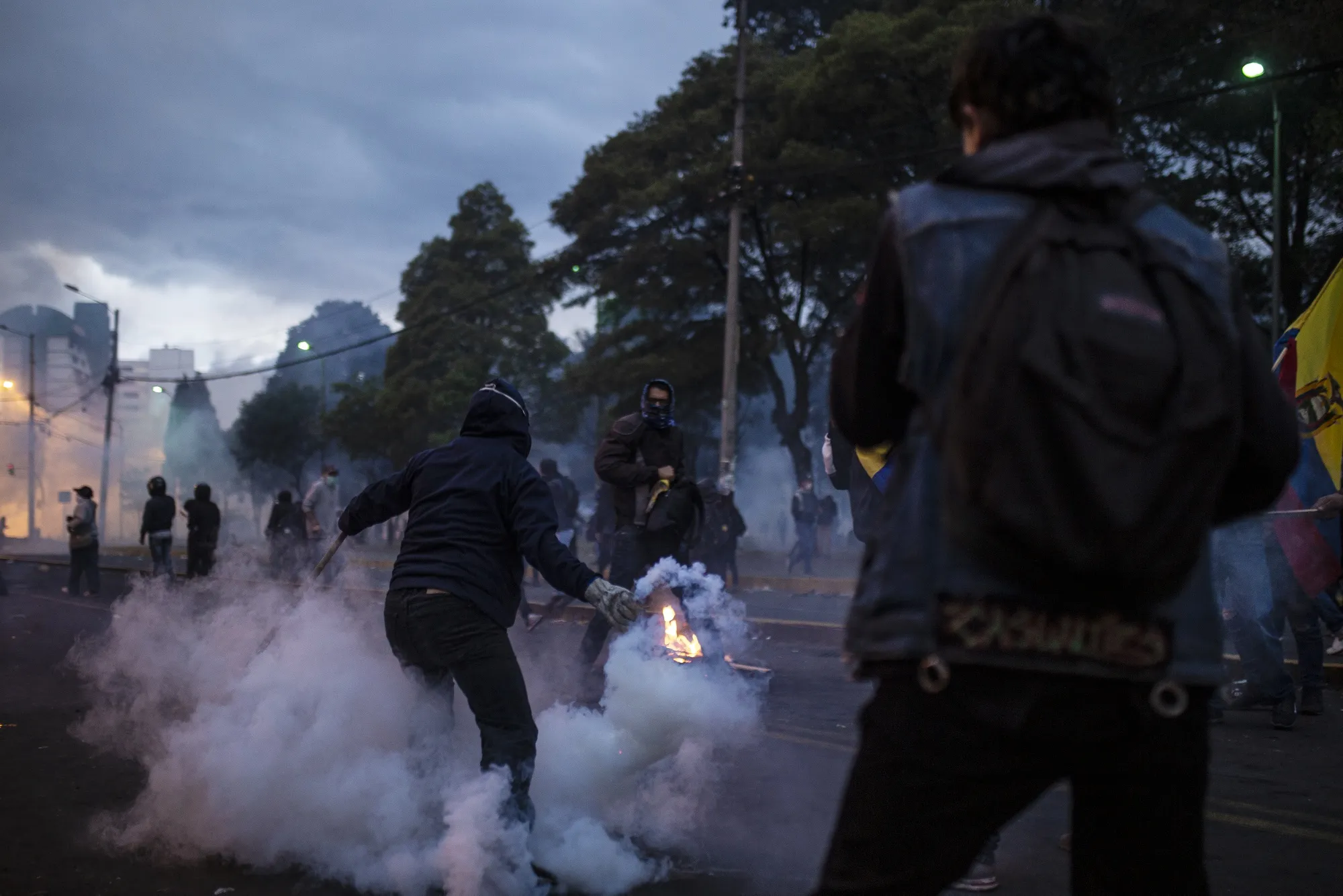 A demonstrator returns a tear gas canister during a protest in the El Ejido Park neighborhood of Quito on&nbsp;Oct. 9.
