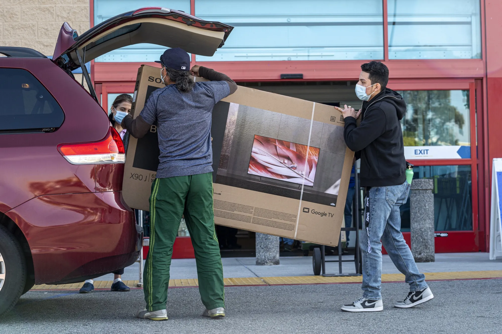 Shoppers load a television into a vehicle at a Best Buy store on Black Friday in San Carlos, California, on Nov. 26, 2021.