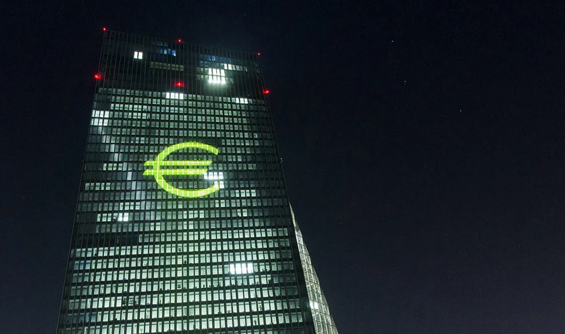 An illuminated euro currency symbol is projected on to the European Central Bank (ECB) headquarters during the Luminale light festival in Frankfurt, Germany, on Thursday, March 17, 2016. European government bonds climbed after the Federal Reserve signaled that it will raise interest rates at a slower pace than previously estimated, bolstering demand for fixed-income securities around the world.