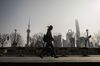 A pedestrian walks along the Bund as buildings in the Lujiazui Financial District stand in the distance in Shanghai, China, on Monday, Feb. 26, 2018. Xi Jinping's decision to cast aside China's presidential term limits is stoking concern he also intends to shun international rules on trade and finance, even as he champions them on the world stage.
