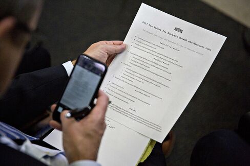 米政権の税制案文書の写真を撮る記者