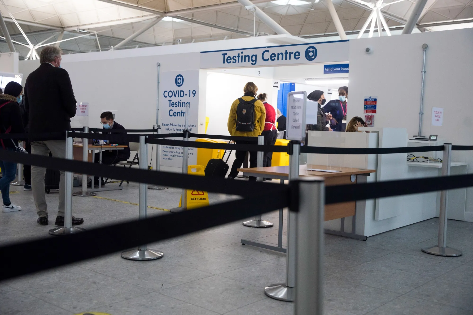 Passengers wait at the entrance to a Covid-19 testing centre at London Stansted Airport in Stansted, U.K., on Jan. 8.
