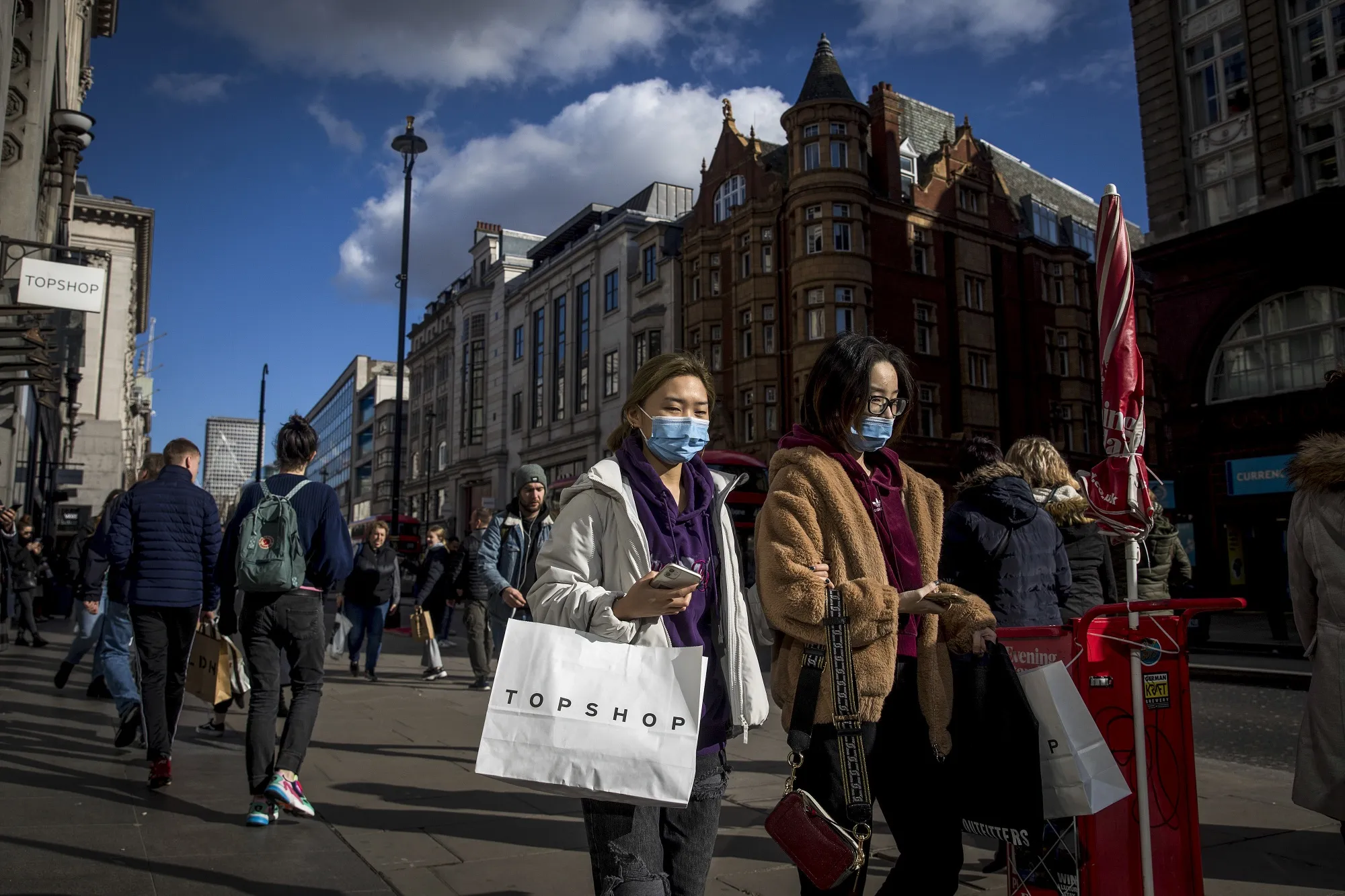 People wear protective face masks as they walk on Oxford Street in London.