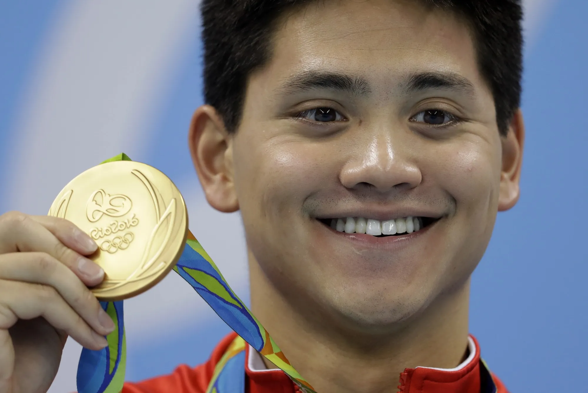 Singapore's Joseph Schooling shows off his gold medal in the men's 100-meter butterfly medals ceremony during the swimming competitions at the 2016 Summer Olympics, Friday, Aug. 12, 2016, in Rio de Janeiro, Brazil. Schooling, who beat Michael Phelps in the 100-meter butterfly to win Singapore's first and only Olympic gold medal at Rio de Janeiro in 2016, announced his retirement, Tuesday, April 2, 2024. (AP Photo/Michael Sohn, File)