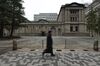A pedestrian walks past the Bank of Japan (BOJ) headquarters in Tokyo, Japan, on Thursday, Dec. 19, 2019. The BOJ left policy untouched Thursday as a government stimulus package, progress in U.S.-China trade talks and signs of a bottoming of the global slowdown brightened the economic outlook.